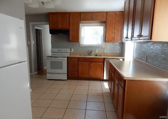 kitchen featuring sink, light tile patterned floors, decorative backsplash, and white appliances