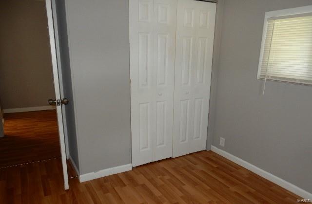 unfurnished bedroom featuring a closet and hardwood / wood-style floors