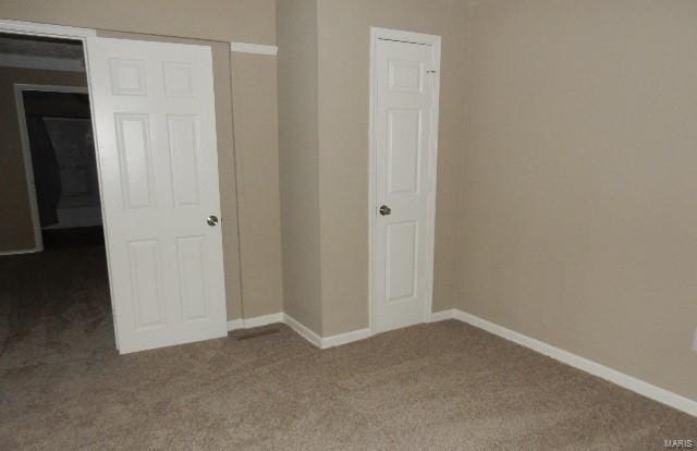 unfurnished bedroom with a closet and carpet floors