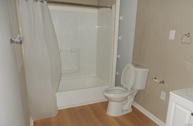 full bathroom featuring vanity, toilet, shower / bath combo with shower curtain, and hardwood / wood-style floors