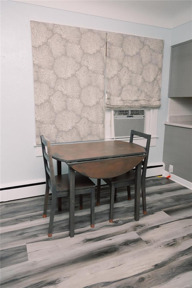 dining room featuring cooling unit, a baseboard heating unit, and dark hardwood / wood-style flooring