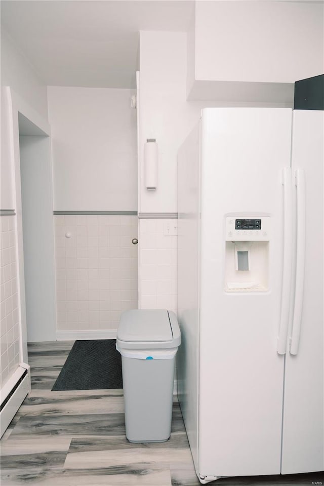 bathroom with wood-type flooring, tile walls, and toilet