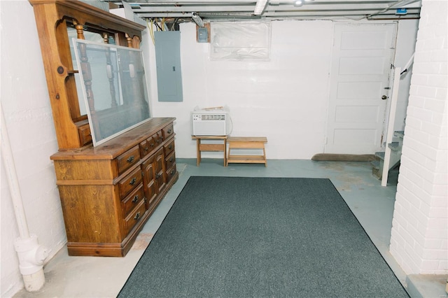 basement featuring electric panel and a wall mounted air conditioner