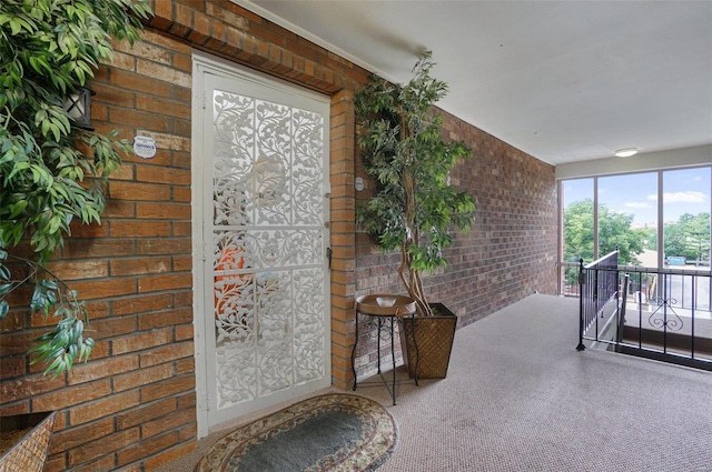 hallway with brick wall and carpet flooring