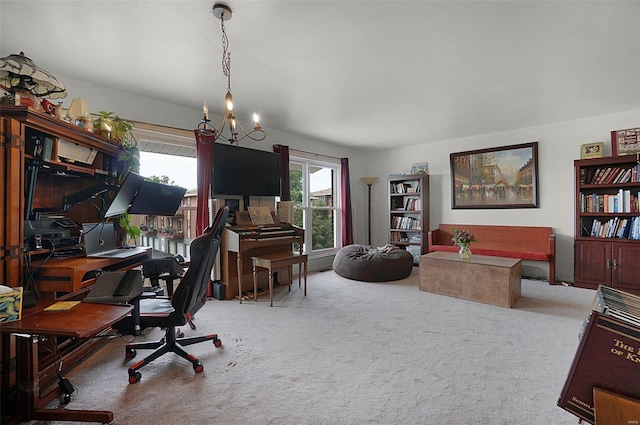 carpeted home office featuring a chandelier