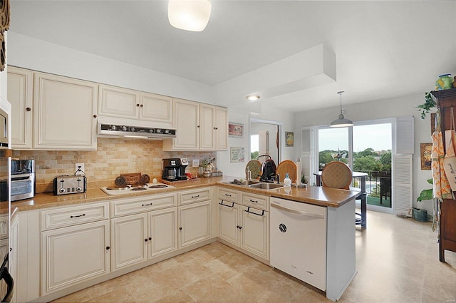 kitchen featuring pendant lighting, white appliances, and cream cabinetry