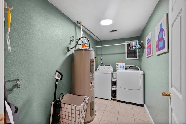 clothes washing area with electric water heater, washer and dryer, and light tile patterned floors