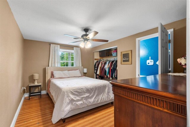 bedroom with light hardwood / wood-style flooring, a closet, and ceiling fan