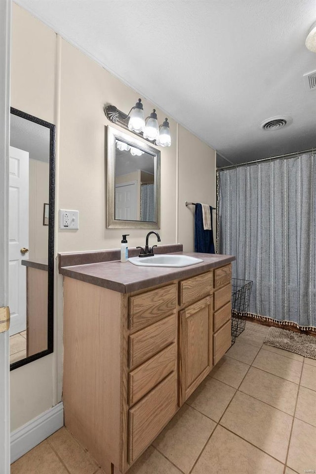 bathroom with a shower with curtain, vanity, and tile patterned flooring