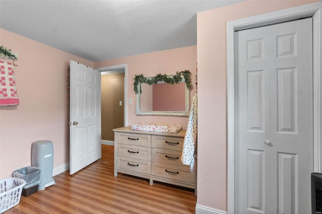 bedroom featuring light hardwood / wood-style flooring and a textured ceiling