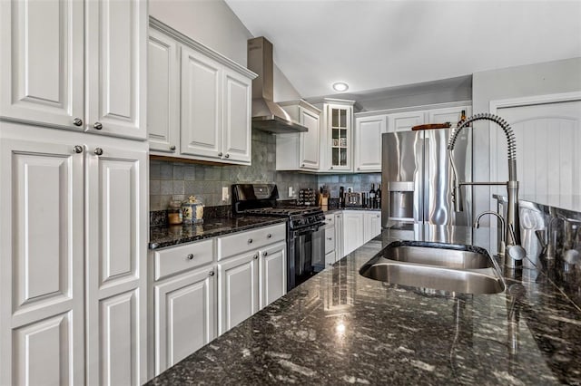 kitchen with white cabinets, wall chimney range hood, decorative backsplash, sink, and black gas stove