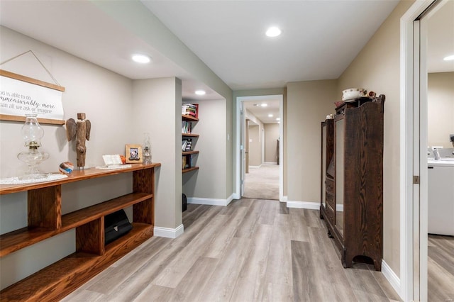 hall featuring light hardwood / wood-style floors and washer / dryer