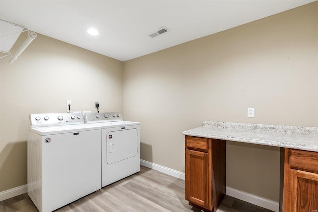 washroom with independent washer and dryer and light wood-type flooring