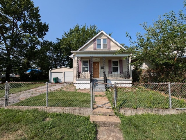 bungalow with an outbuilding, a garage, a front lawn, and covered porch