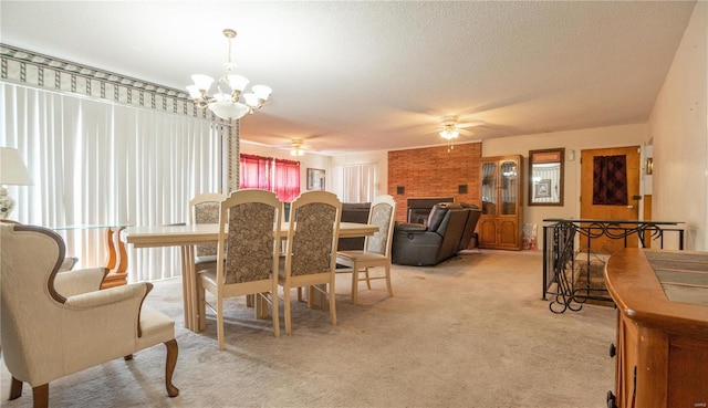 carpeted dining area with ceiling fan with notable chandelier, a brick fireplace, brick wall, and a textured ceiling