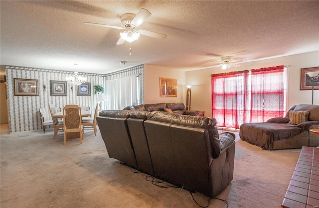 carpeted living room featuring a textured ceiling and ceiling fan with notable chandelier