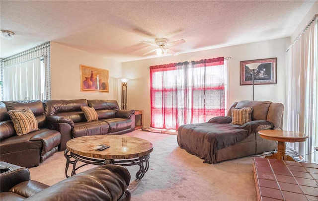 living room featuring ceiling fan, a textured ceiling, and light carpet