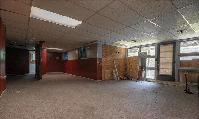 interior space featuring carpet flooring and a drop ceiling