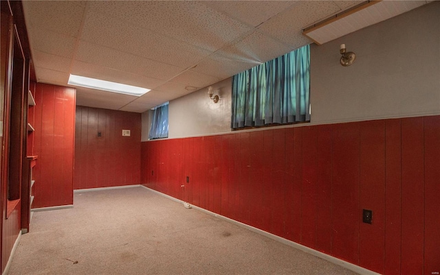 basement featuring carpet floors and a paneled ceiling