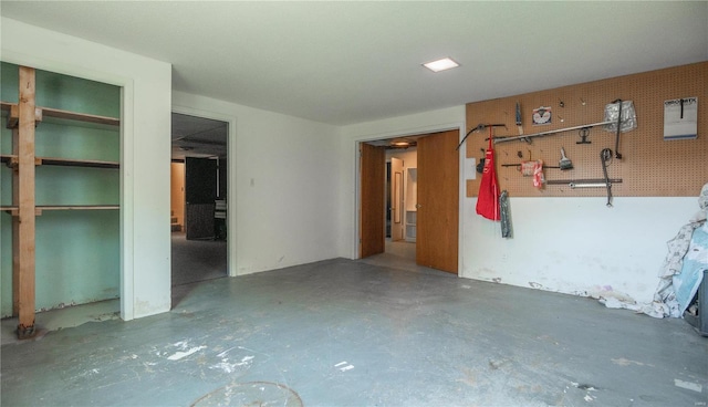 unfurnished bedroom featuring multiple closets, a workshop area, and concrete floors