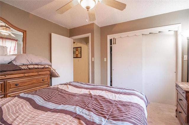 bedroom with a textured ceiling, ceiling fan, and light colored carpet