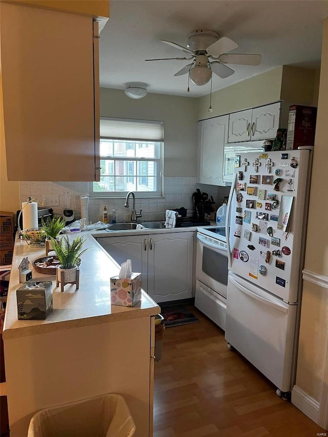 kitchen with white appliances, backsplash, white cabinetry, ceiling fan, and wood-type flooring