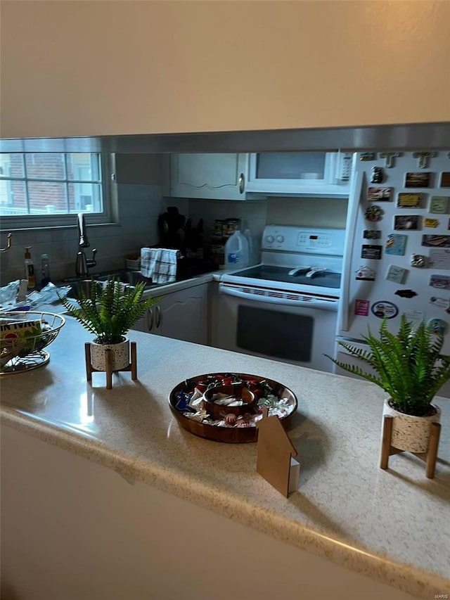 kitchen with sink, tasteful backsplash, and white appliances