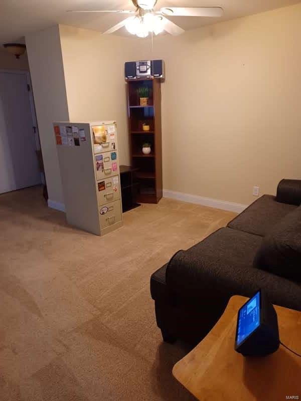 living room with light colored carpet and ceiling fan