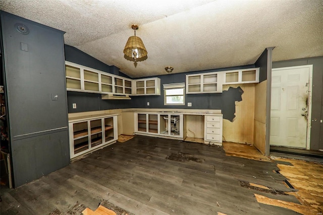 unfurnished living room with dark hardwood / wood-style floors, vaulted ceiling, and a textured ceiling