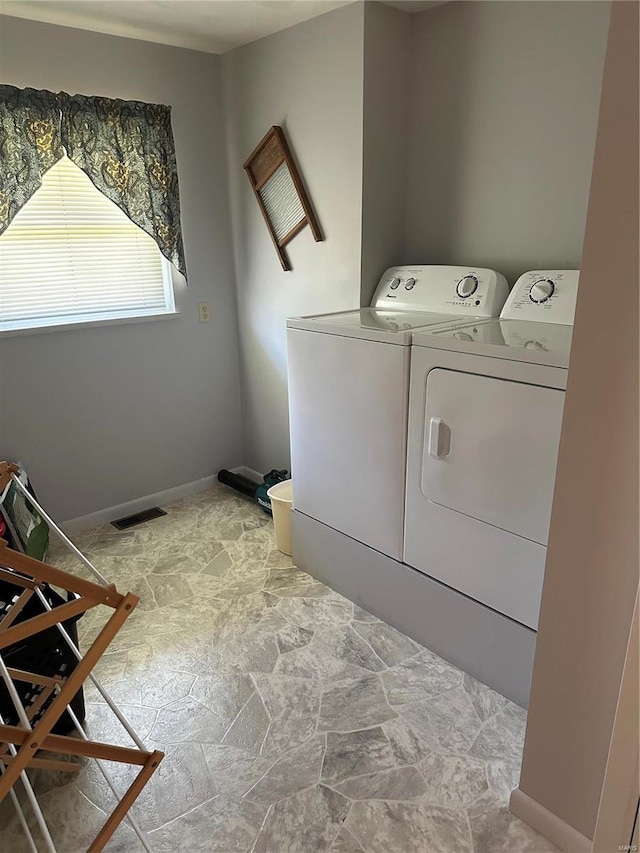 laundry area with light tile patterned floors and washer and dryer