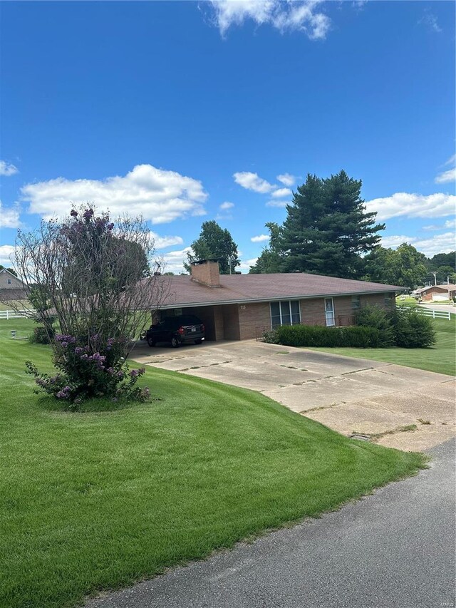 view of front of home with a front lawn and a carport