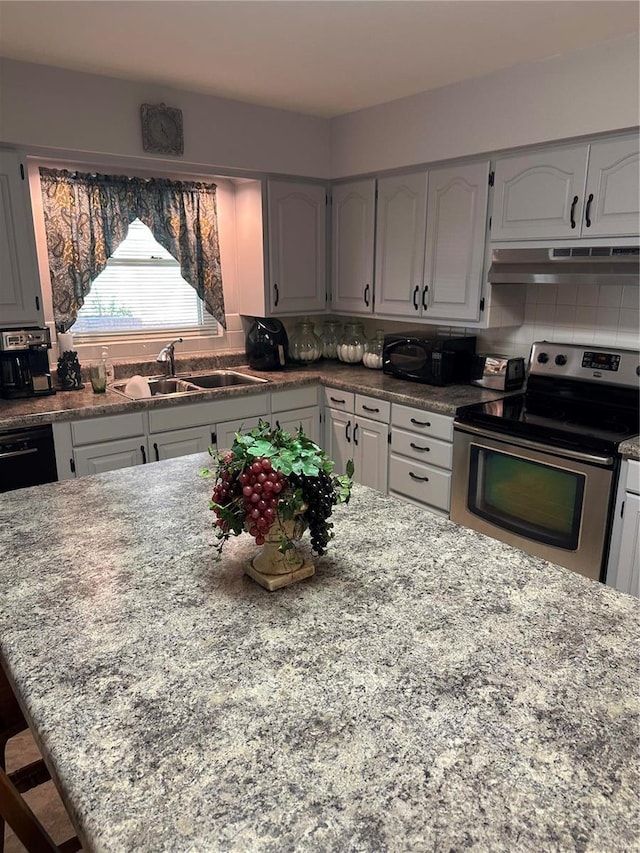 kitchen with sink, light stone countertops, decorative backsplash, and stainless steel range with electric stovetop