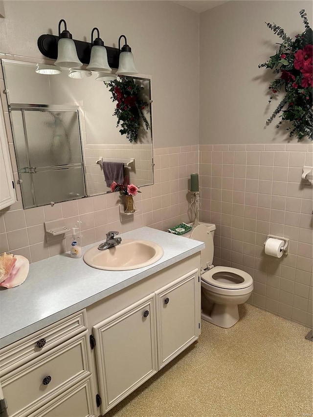 bathroom with toilet, walk in shower, vanity, backsplash, and tile walls