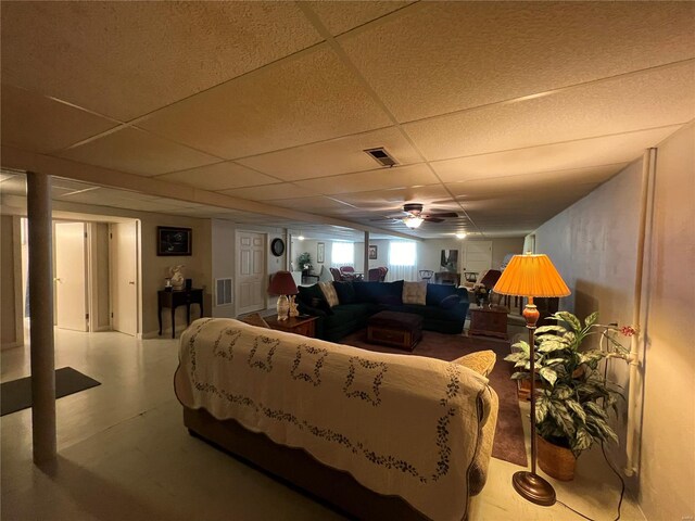 living room with ceiling fan and a drop ceiling