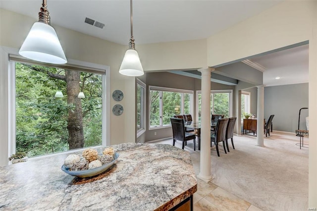 dining space featuring decorative columns and light carpet