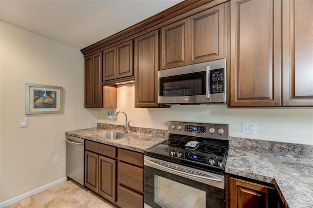 kitchen featuring appliances with stainless steel finishes, light tile patterned floors, and sink