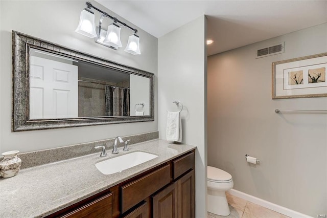 bathroom featuring tile patterned flooring, toilet, and vanity