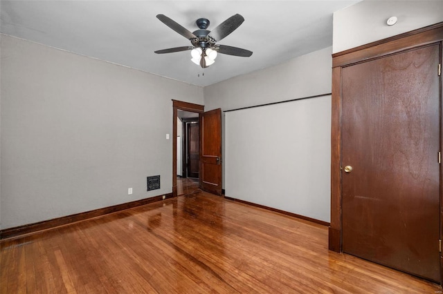 unfurnished bedroom featuring ceiling fan, light hardwood / wood-style floors, and a closet