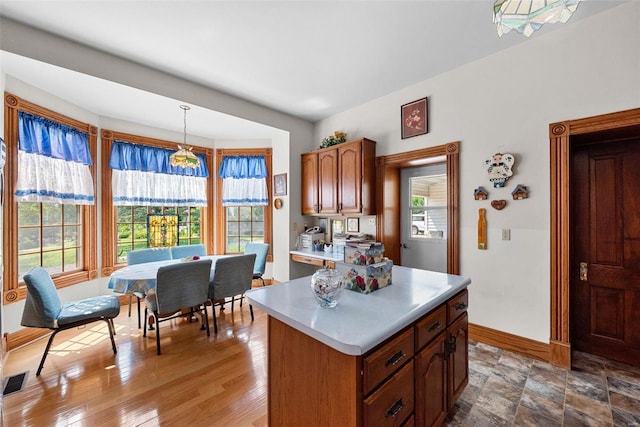 kitchen featuring a wealth of natural light, a center island, light countertops, and hanging light fixtures