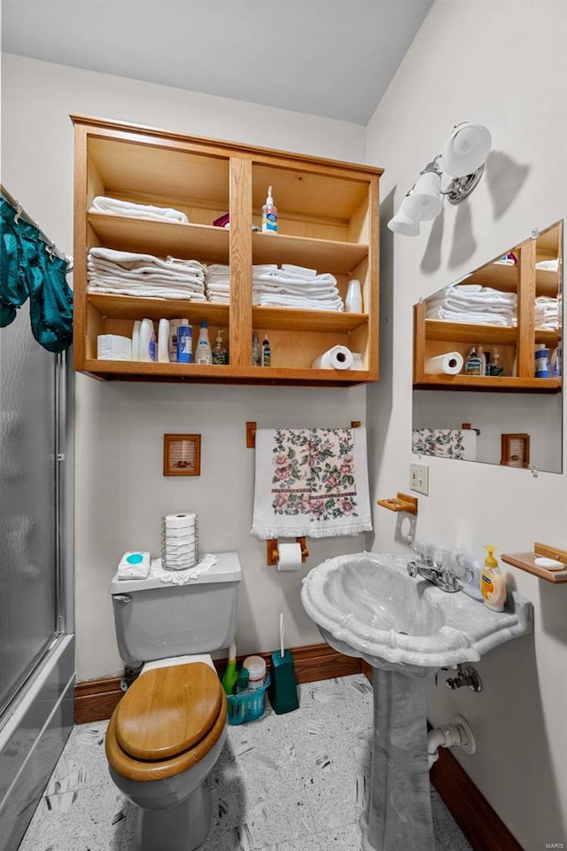 full bath featuring a sink, toilet, and baseboards