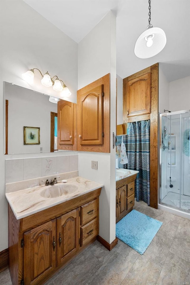 bathroom featuring backsplash, a shower stall, and vanity