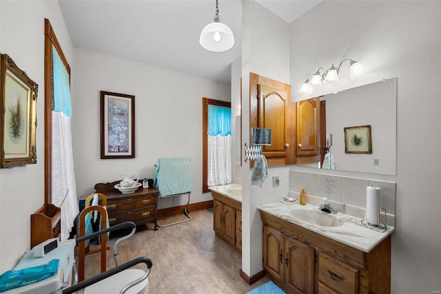 bathroom with baseboards, vanity, and decorative backsplash