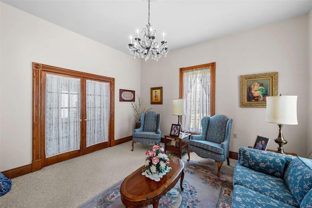 living area with baseboards, a chandelier, carpet flooring, and french doors