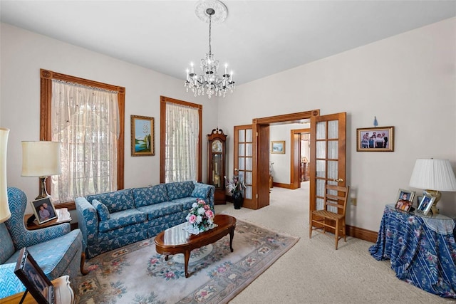 living area with french doors, carpet flooring, baseboards, and an inviting chandelier