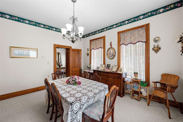 dining space with baseboards, a notable chandelier, and carpet flooring