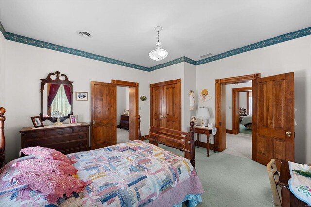 bedroom with light carpet, a closet, visible vents, and baseboards