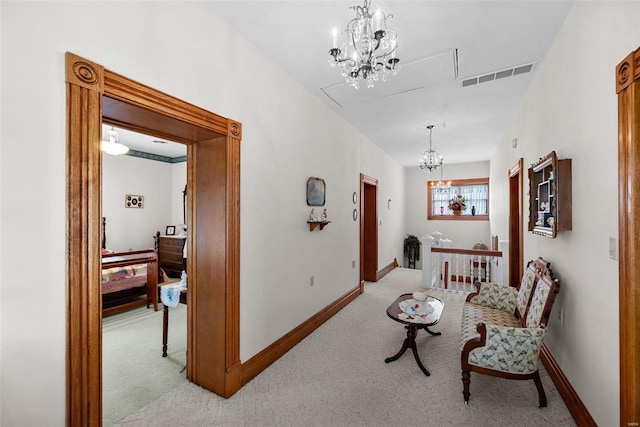 corridor with light colored carpet, visible vents, baseboards, and an inviting chandelier