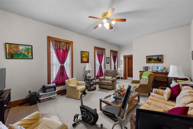 living room with baseboards, a ceiling fan, and light colored carpet