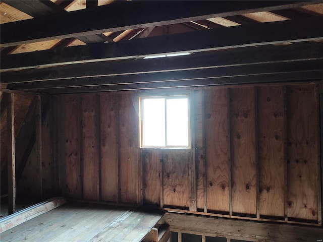 below grade area with light wood-type flooring and wooden walls