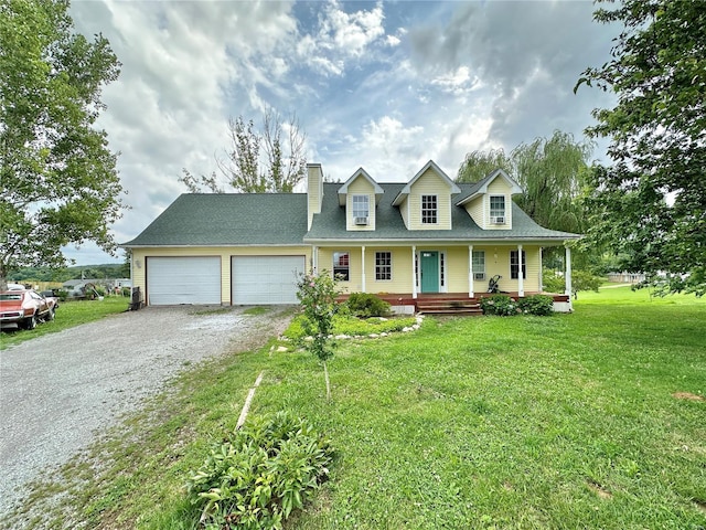 view of front of house featuring a garage, a front yard, and covered porch